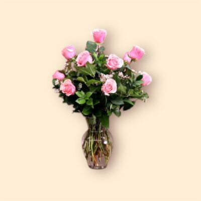 dozen pink roses in a glass vase.