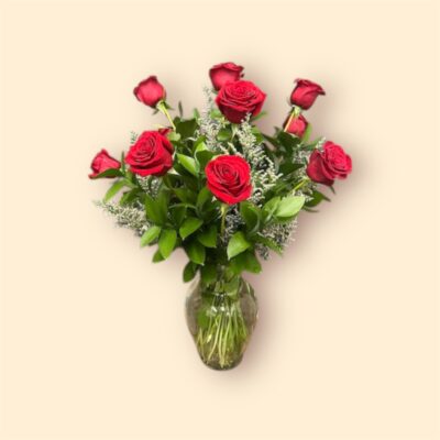 twelve red roses and greenery in a glass vase