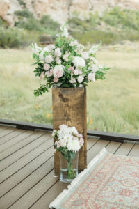 Wedding florals on a wood platform.