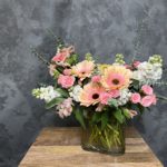 Bouquet of peach Gerbera daisies in glass vase.