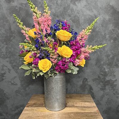 metal bucket filled with flowers on a table