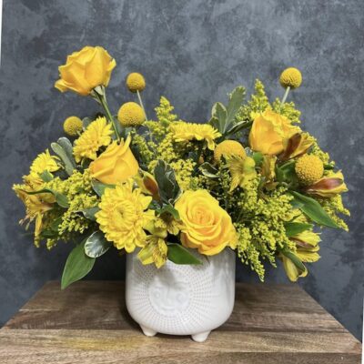 large bouquet of yellow flowers in a white vase