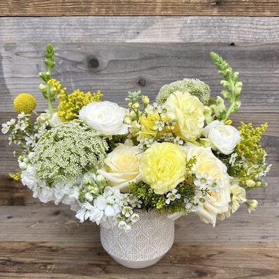 yellow and white flowers in a white vase