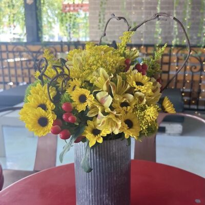 yellow flower arrangement in a metal vase