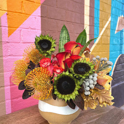 floral arrangement in a brown and white vase