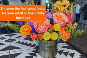 colorful flowers in a vase on a table at a restaurant with text overlayed on the image that reads 'enhance the feel-good factor for your retail or hospitality business'