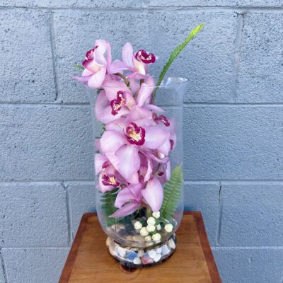 pink orchids stacked in a clear vase