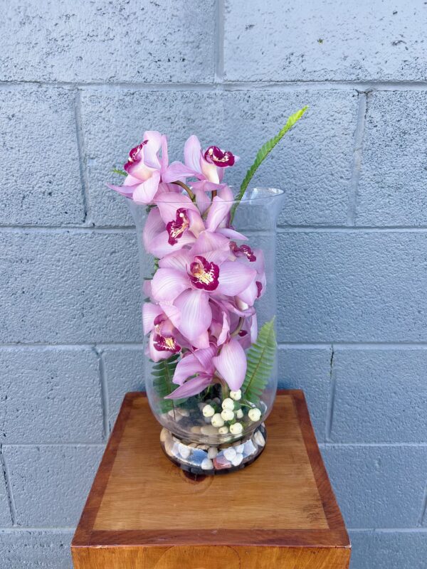 pink orchids stacked in a clear vase