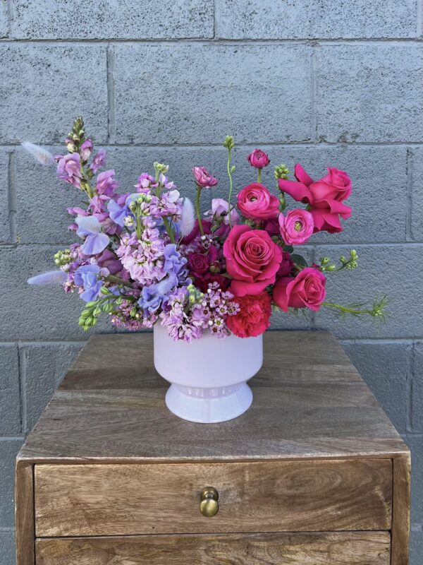 purple and red valentines day flower arrangement in a white vase