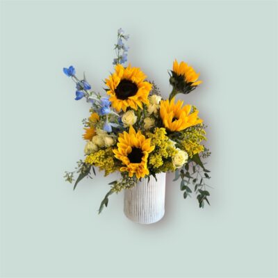 spring flower arrangement with sunflowers in a white vase